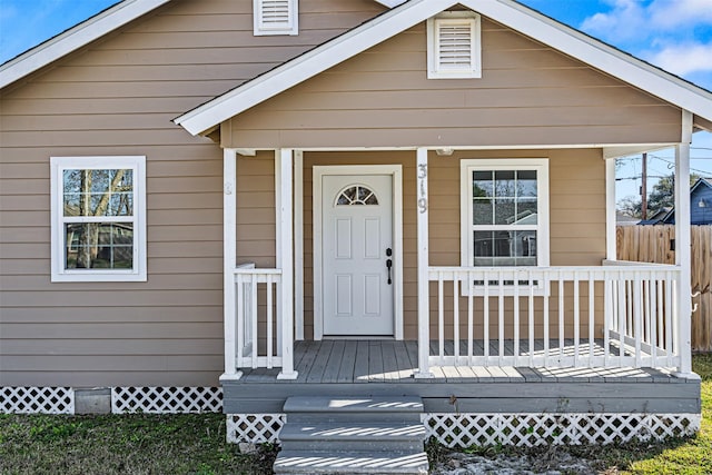 view of front of property featuring crawl space, covered porch, and fence