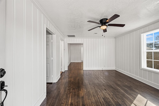 empty room featuring dark wood-style floors, visible vents, a textured ceiling, and a ceiling fan