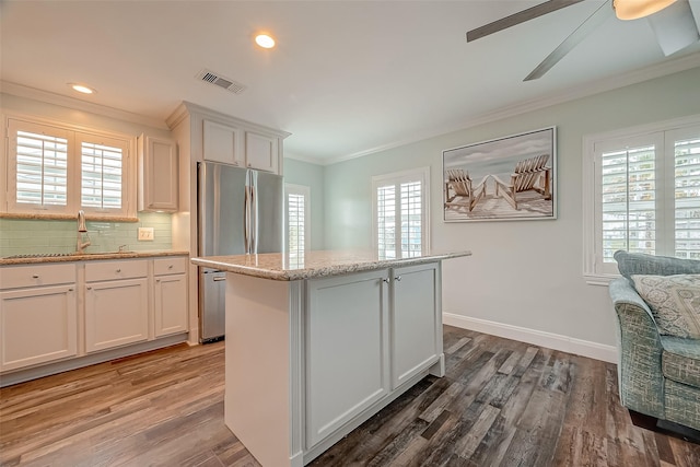 411 Olive St, Surfside Beach, TX 77541 - kitchen with a sink, crown molding, decorative backsplash, and wood finished floors