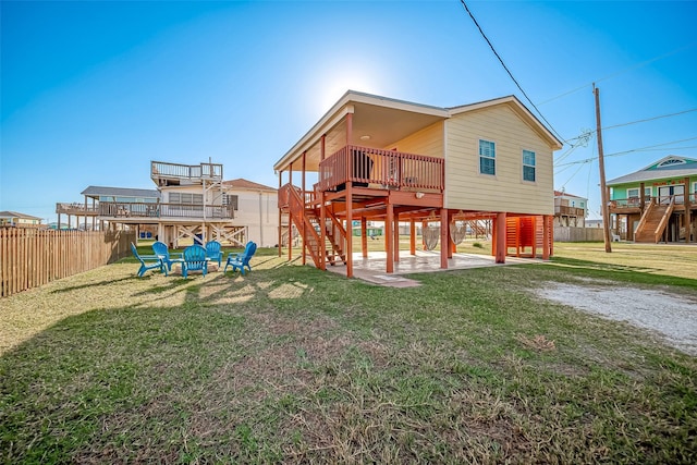 411 Olive St, Surfside Beach, TX 77541 - rear view of house with a deck, a yard, stairway, and a fenced backyard