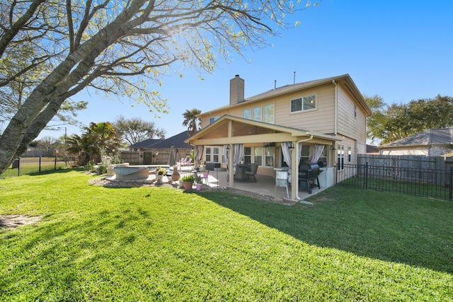 back of house with a fenced backyard, a chimney, a lawn, and a patio