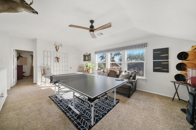 rec room with light colored carpet, visible vents, vaulted ceiling, ceiling fan, and baseboards