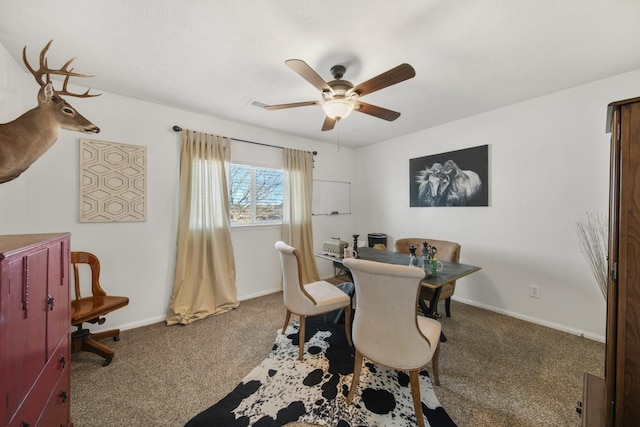 carpeted office space with ceiling fan and baseboards