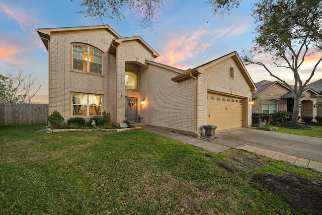 traditional home with brick siding, a lawn, driveway, and an attached garage