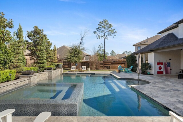 view of pool with a patio area, fence, a fenced in pool, and an in ground hot tub