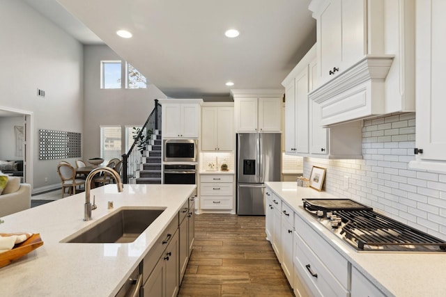 kitchen featuring white cabinetry, appliances with stainless steel finishes, dark wood finished floors, and a sink