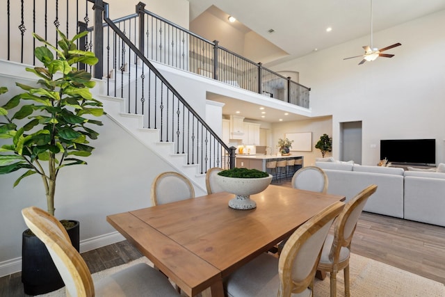 dining room featuring light wood finished floors, baseboards, ceiling fan, stairs, and recessed lighting