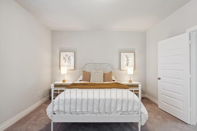 bedroom featuring light colored carpet and baseboards