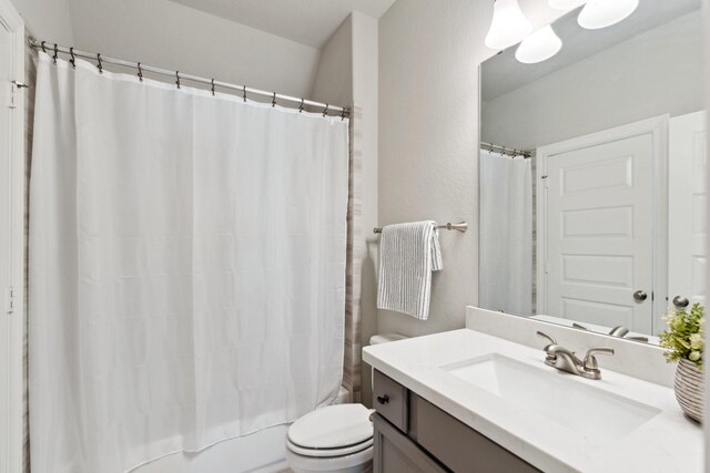 full bath featuring shower / bath combo with shower curtain, vanity, and toilet