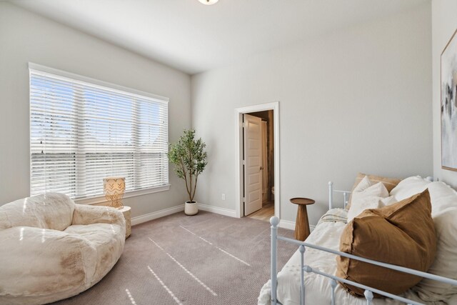 bedroom featuring light carpet and baseboards