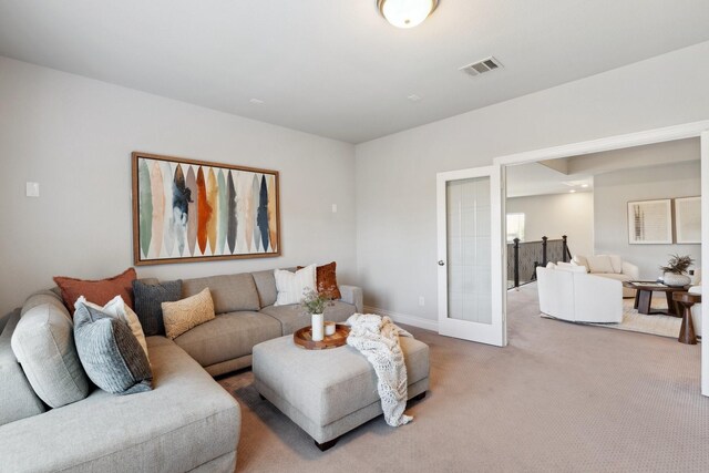 living room featuring carpet floors, french doors, visible vents, and baseboards