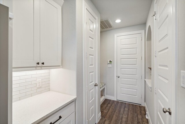 interior space with baseboards, visible vents, dark wood-style flooring, and recessed lighting