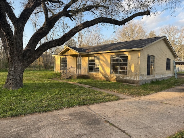 ranch-style home featuring a front lawn and brick siding