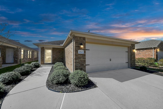 view of front of house featuring a garage, brick siding, and driveway