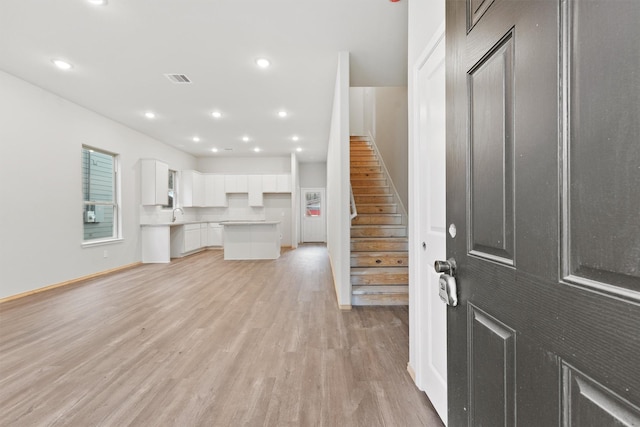 foyer featuring visible vents, baseboards, stairway, light wood-style floors, and recessed lighting