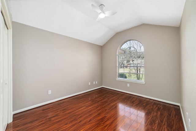 spare room with lofted ceiling, ceiling fan, wood finished floors, and baseboards