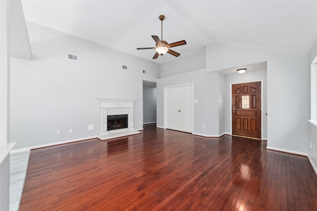 unfurnished living room featuring visible vents, a fireplace with raised hearth, dark wood-type flooring, a ceiling fan, and vaulted ceiling