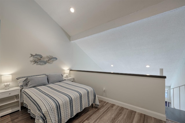 bedroom featuring lofted ceiling, baseboards, and wood finished floors