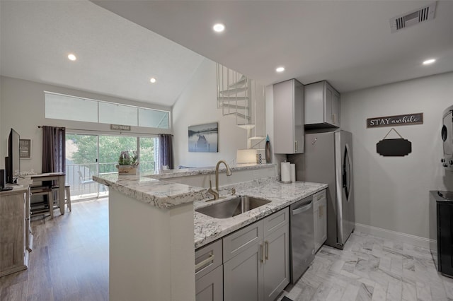 kitchen with visible vents, a peninsula, a sink, gray cabinetry, and stainless steel dishwasher