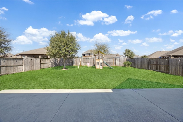 view of yard featuring a patio area, a playground, and a fenced backyard