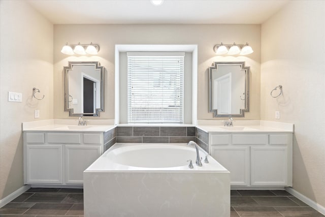 full bath with two vanities, a sink, and a bath