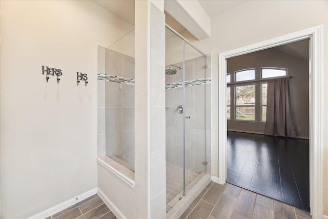 full bath with a stall shower, vaulted ceiling, baseboards, and wood tiled floor