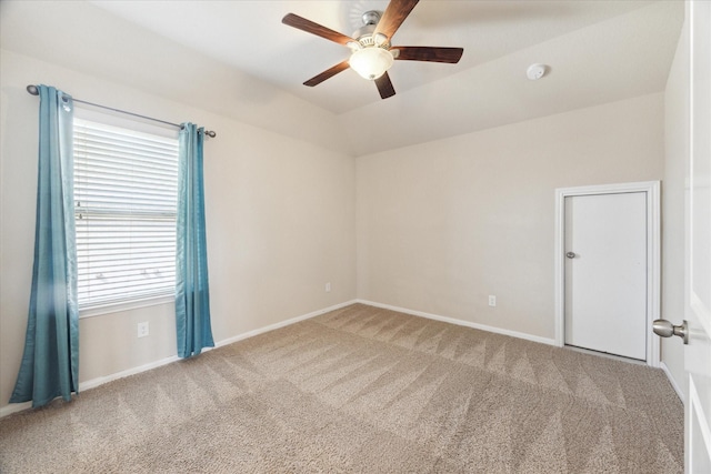 carpeted spare room with a ceiling fan, lofted ceiling, and baseboards