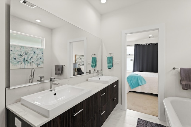 ensuite bathroom featuring plenty of natural light, connected bathroom, visible vents, and a sink