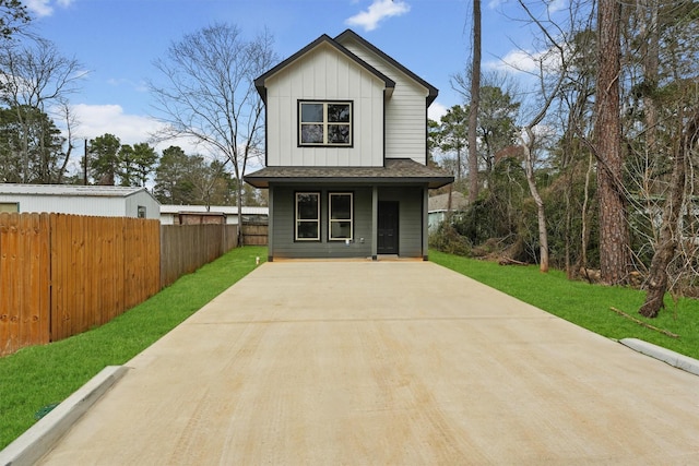 exterior space featuring fence, a porch, board and batten siding, and a front yard