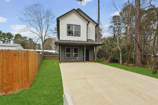 view of front of property featuring a front lawn, board and batten siding, a porch, and fence