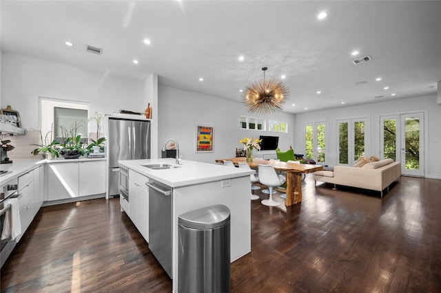 kitchen featuring stainless steel appliances, light countertops, open floor plan, and visible vents