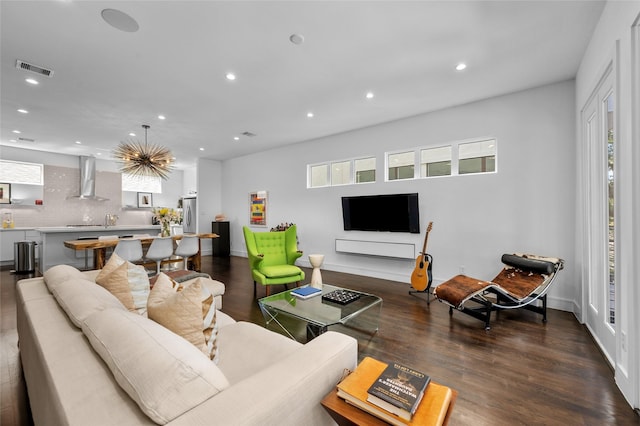 living room with baseboards, visible vents, wood finished floors, and recessed lighting