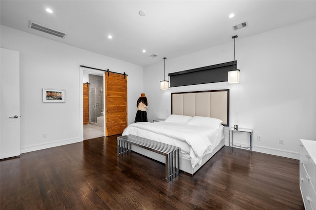 bedroom featuring a barn door, wood finished floors, visible vents, and recessed lighting