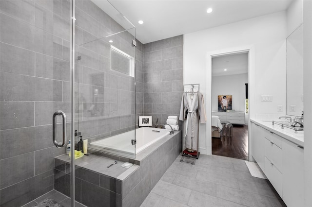 ensuite bathroom with a garden tub, connected bathroom, recessed lighting, a shower stall, and tile patterned floors