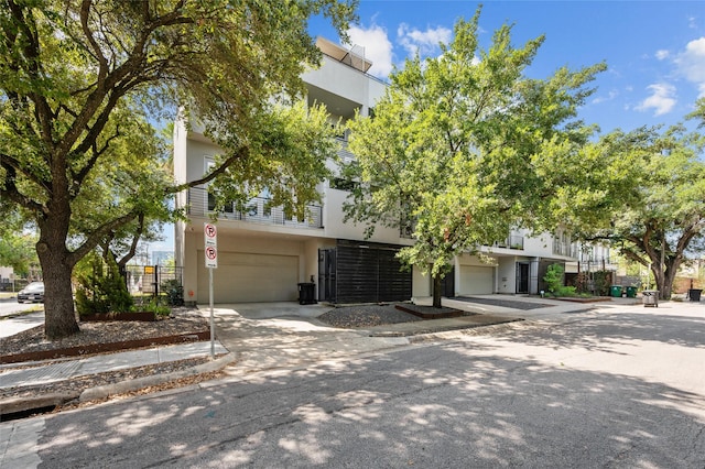 multi unit property featuring driveway, an attached garage, and stucco siding