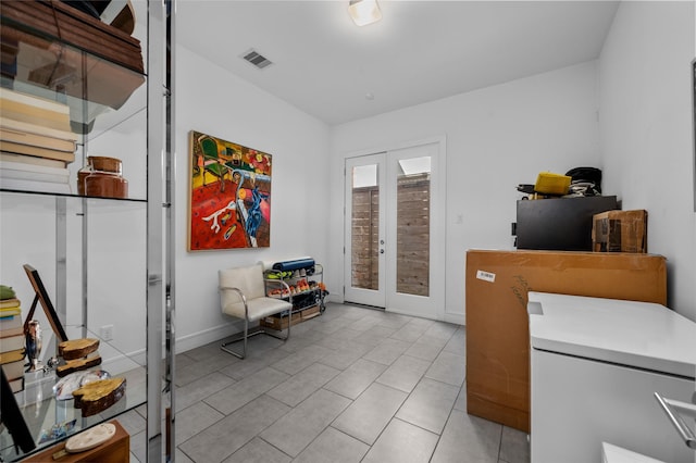 interior space with baseboards, visible vents, and french doors