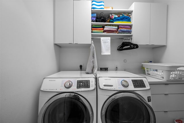 laundry room with cabinet space and washing machine and clothes dryer