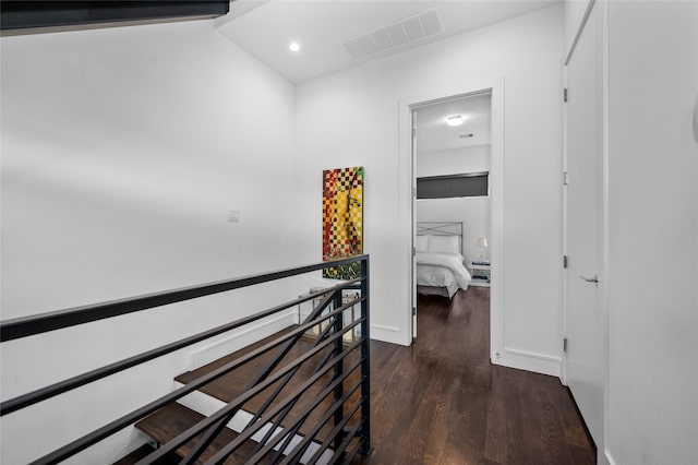 hall with baseboards, visible vents, dark wood finished floors, an upstairs landing, and recessed lighting