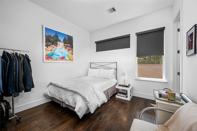 bedroom featuring wood finished floors, visible vents, and baseboards