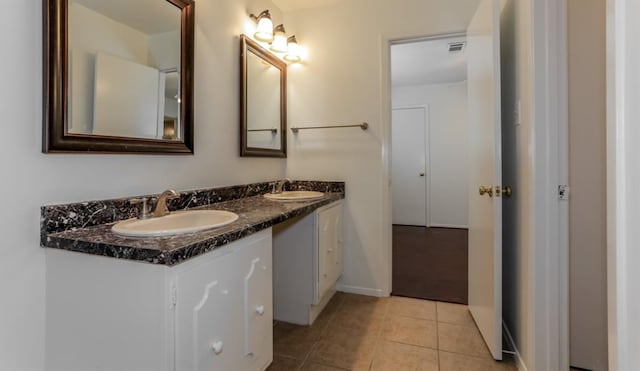 bathroom with double vanity, tile patterned flooring, visible vents, and a sink