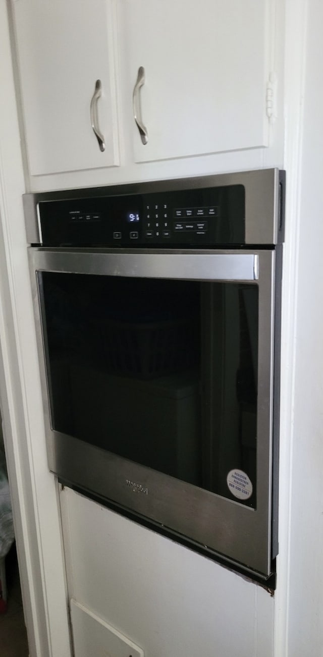 interior details featuring white cabinets and oven