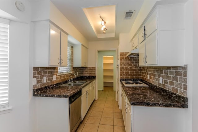 kitchen with visible vents, dishwasher, a tray ceiling, white cabinetry, and a sink