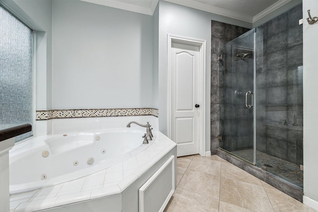 bathroom with tile patterned flooring, a tub with jets, a stall shower, and ornamental molding