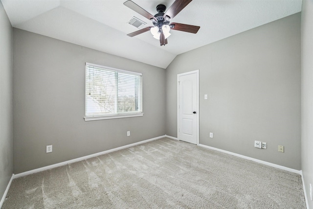 empty room with baseboards, visible vents, lofted ceiling, ceiling fan, and carpet flooring