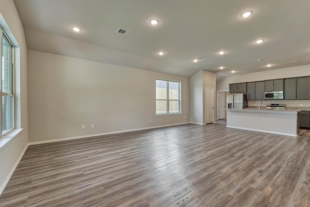 unfurnished living room with visible vents, recessed lighting, baseboards, and wood finished floors