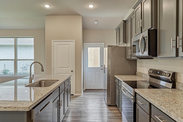 kitchen featuring a center island with sink, recessed lighting, a sink, light wood-style floors, and appliances with stainless steel finishes