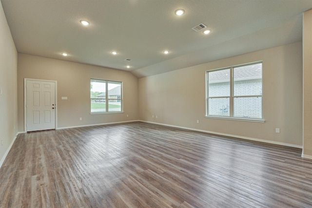 spare room with visible vents, baseboards, vaulted ceiling, recessed lighting, and wood finished floors