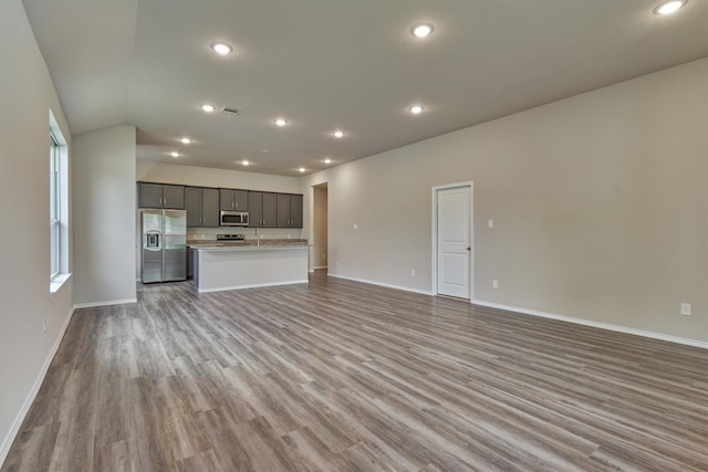 unfurnished living room featuring visible vents, recessed lighting, wood finished floors, and baseboards