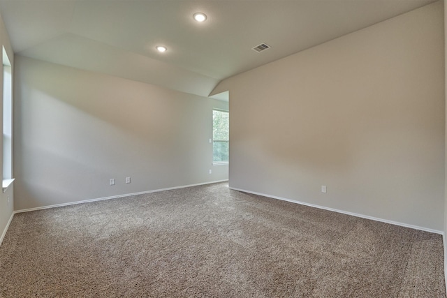 carpeted spare room featuring visible vents, recessed lighting, baseboards, and vaulted ceiling