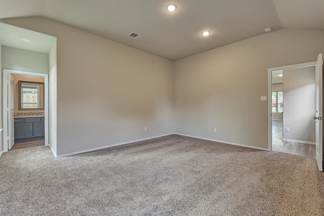 spare room with lofted ceiling, baseboards, visible vents, and carpet floors